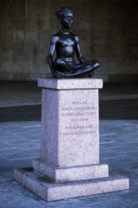 Cross legged girl statue on plinth.
